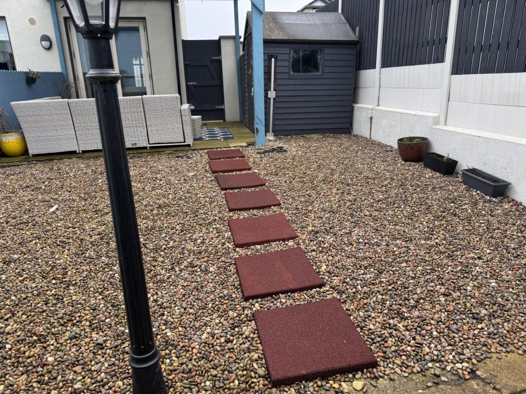 Before — a gravel garden with red stepping stones and a shed, in Skerries
